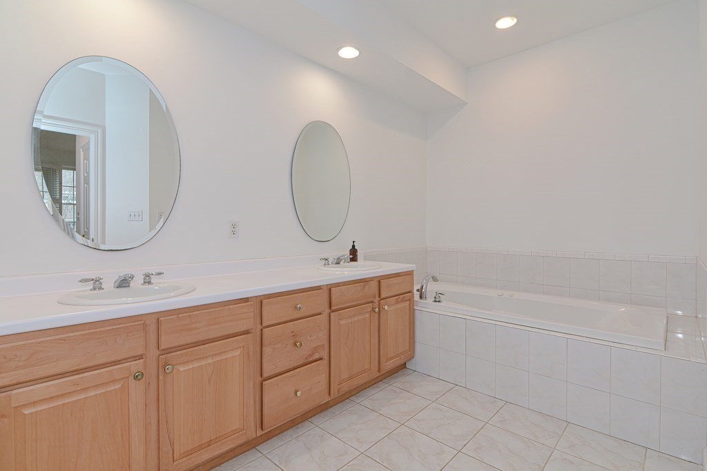 2 Braeburn Lane, Unit 2 Ashland, MA 01721 - Photo 23 of 36 a bathroom with a double vanity sink and a mirror