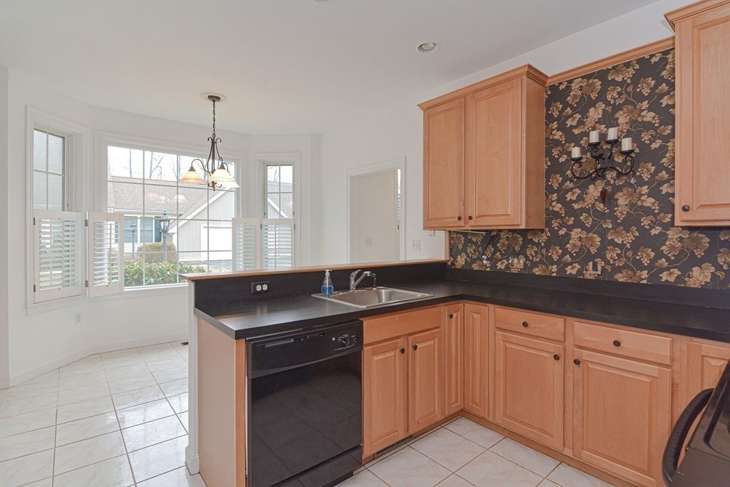 2 Braeburn Lane, Unit 2 Ashland, MA 01721 - Photo 6 of 36 a kitchen with granite countertop white cabinets and white appliances