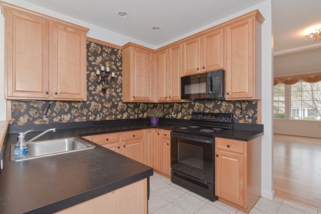 2 Braeburn Lane, Unit 2 Ashland, MA 01721 - Photo 7 of 36 a kitchen with stainless steel appliances granite countertop a sink stove and microwave