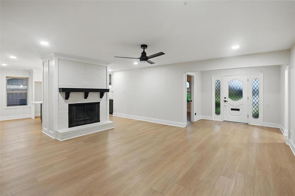 an empty room with fireplace and wooden floor