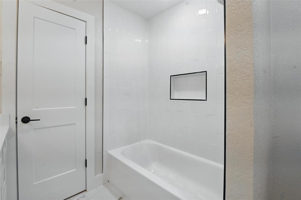 7716 La Risa Drive Dallas, TX 75248 - Photo 28 of 34 a bathroom with a tub and shower