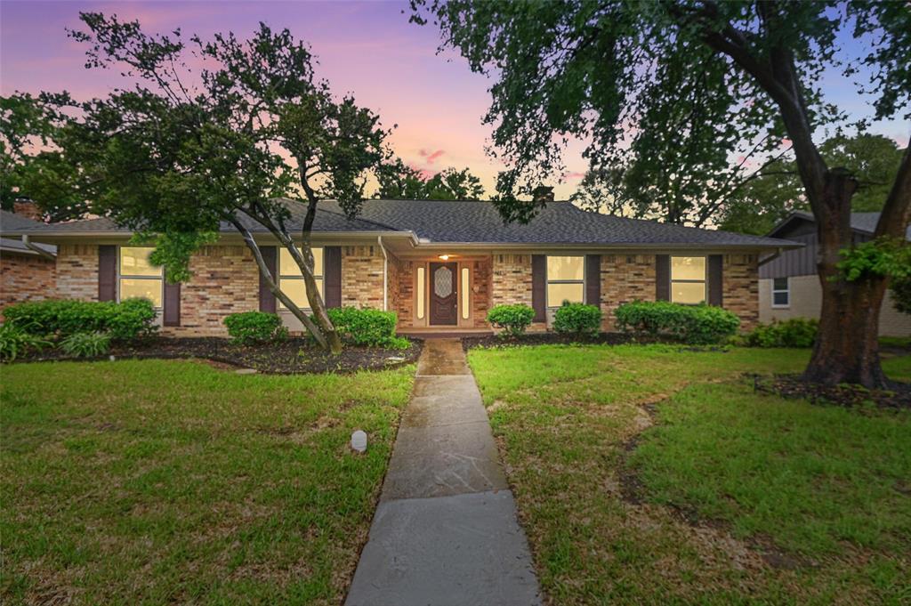 7716 La Risa Drive Dallas, TX 75248 - Photo 29 of 34 a front view of a house with a yard and potted plants