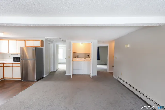 a view of empty room with furniture and refrigerator