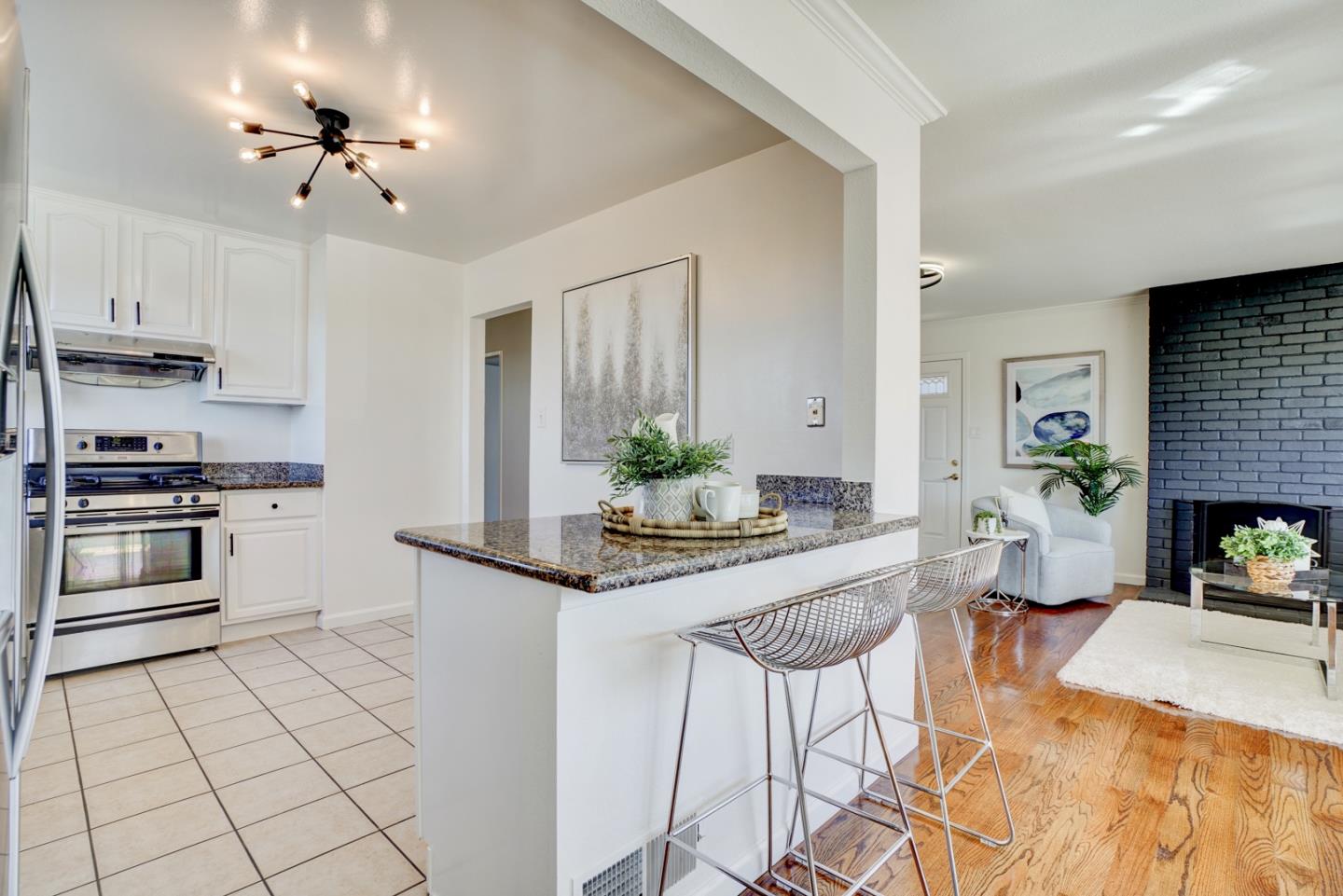 391 Imperial Drive Pacifica, CA 94044 - Photo 17 of 60 a kitchen with stainless steel appliances kitchen island granite countertop a stove a sink and a refrigerator