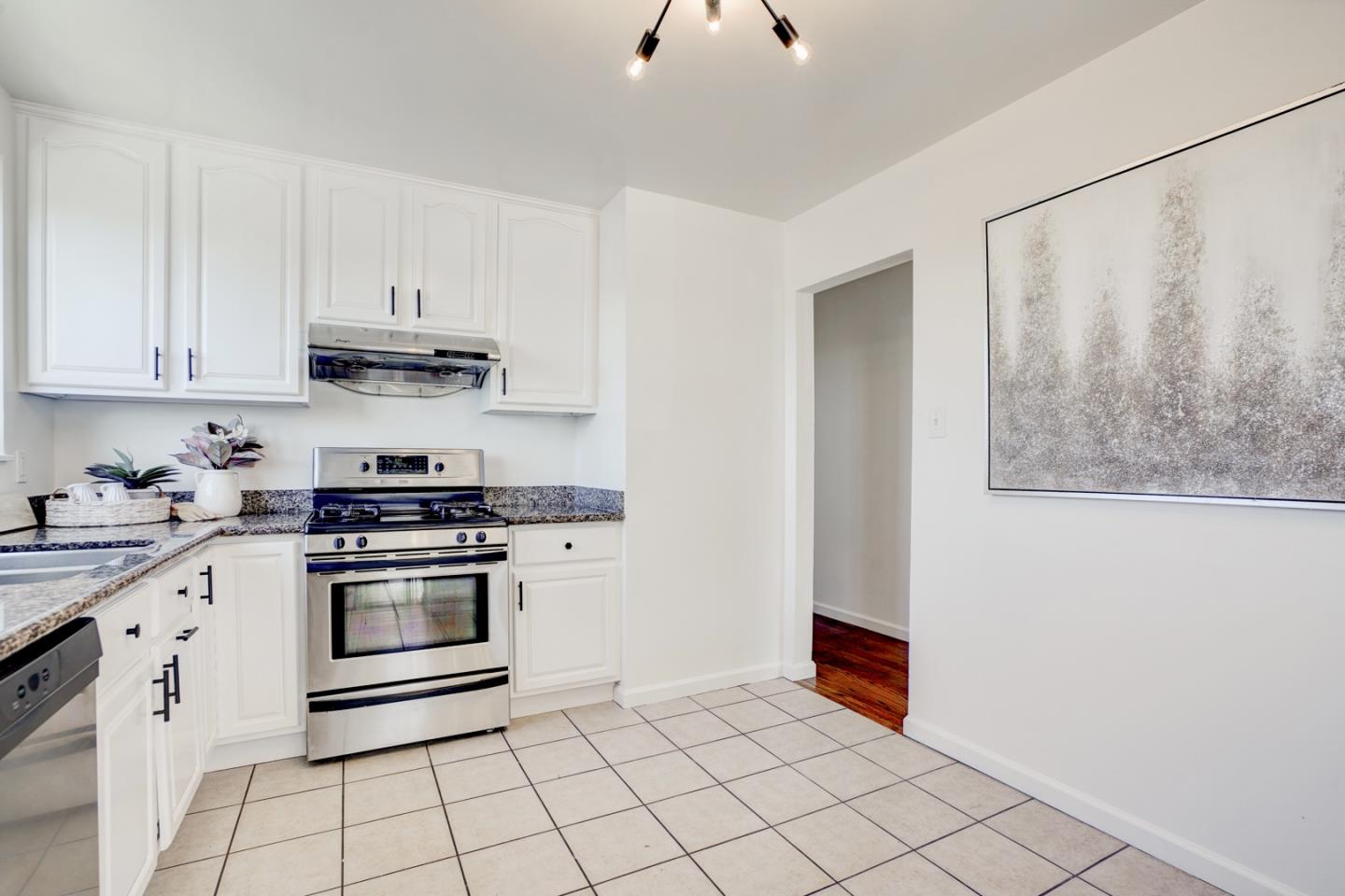 391 Imperial Drive Pacifica, CA 94044 - Photo 18 of 60 a kitchen with stainless steel appliances granite countertop a stove a sink and a refrigerator