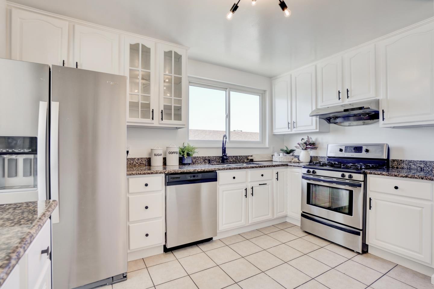 391 Imperial Drive Pacifica, CA 94044 - Photo 19 of 60 a kitchen with granite countertop white cabinets and white stainless steel appliances