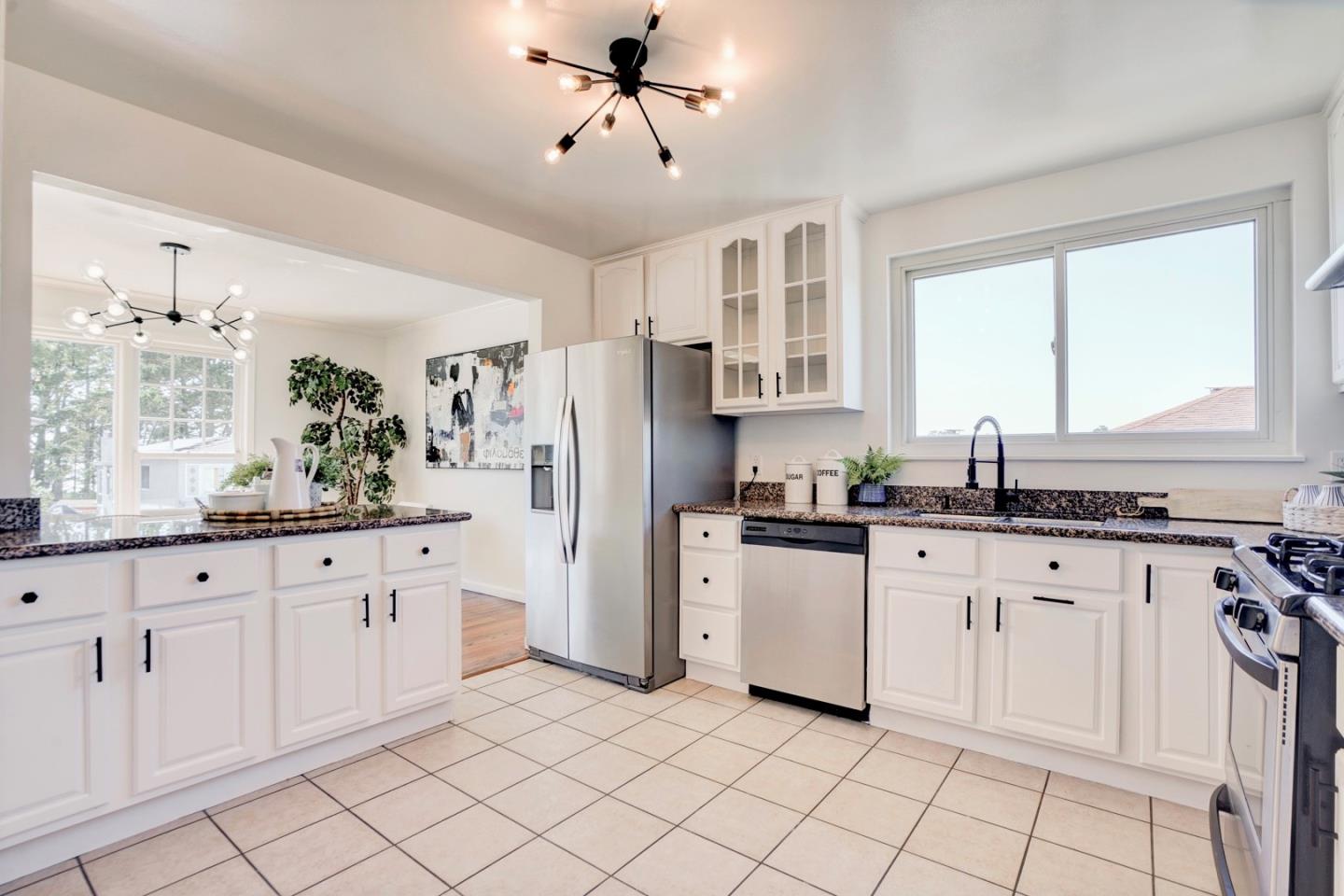 391 Imperial Drive Pacifica, CA 94044 - Photo 20 of 60 a kitchen with granite countertop white cabinets white appliances with a sink and a window