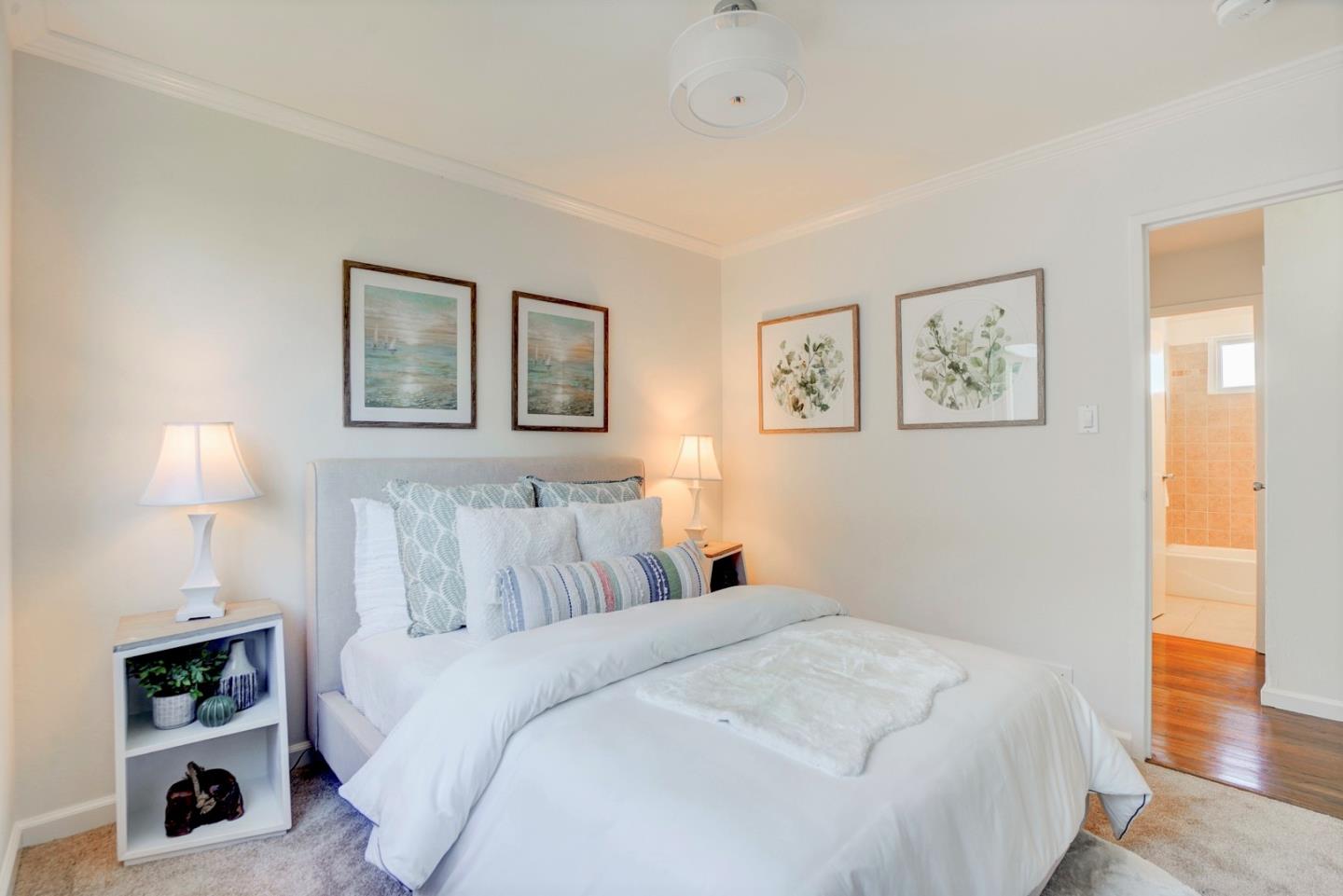 391 Imperial Drive Pacifica, CA 94044 - Photo 33 of 60 a bedroom with a bed and a lamp on dresser with wooden floor