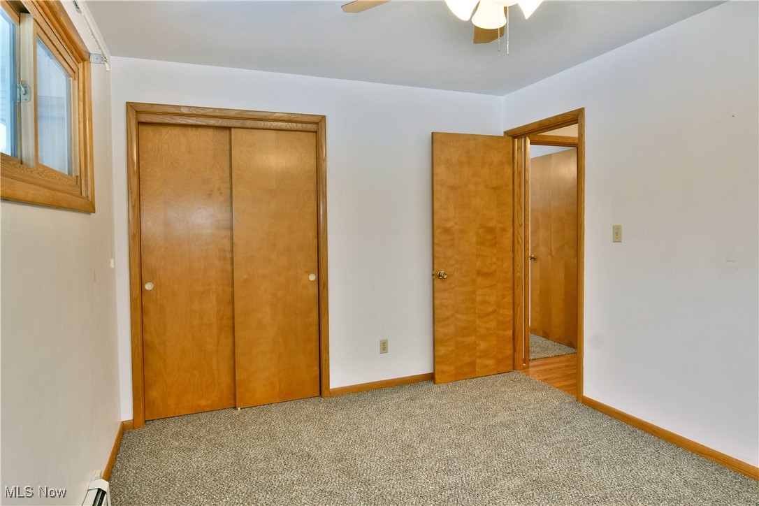 7155 Drake State Line Road Burghill, OH 44404 - Photo 37 of 50 Unfurnished bedroom featuring a closet, carpet, ceiling fan, and a baseboard radiator