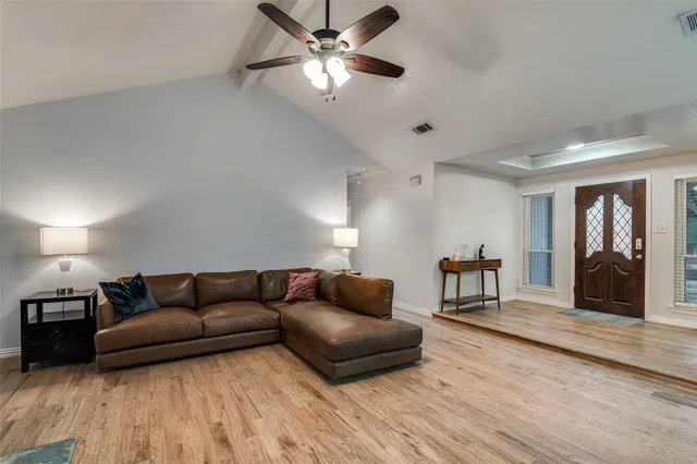 a living room with furniture and a ceiling fan