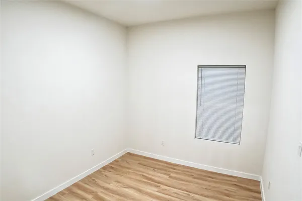 a view of a small space with wooden floor and a window