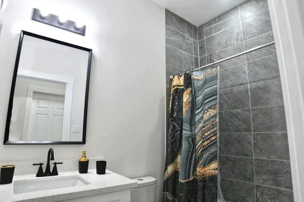 a bathroom with a sink and mirror with toilet