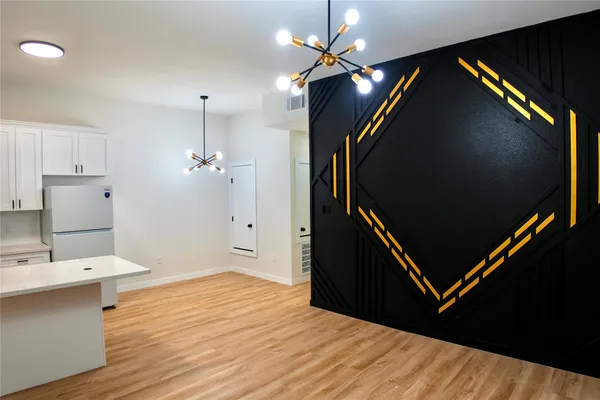 a dinning room with kitchen island a wooden floor and a ceiling fan