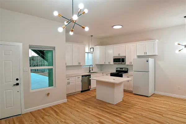 a kitchen with granite countertop white cabinets and appliances