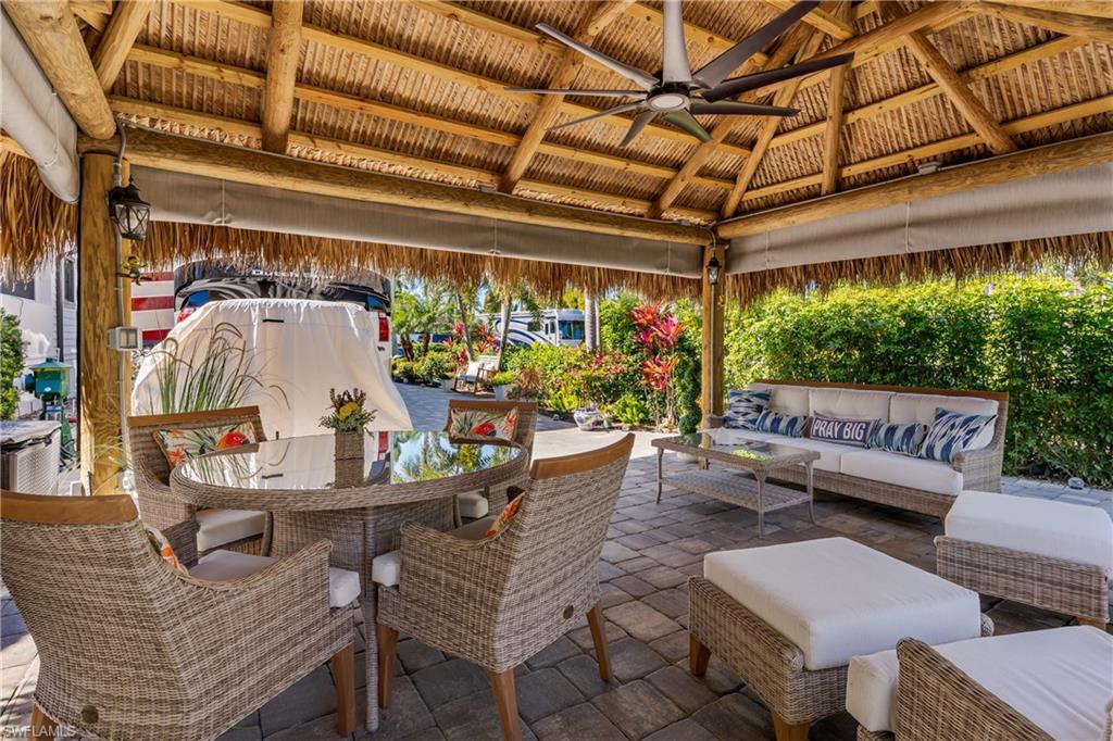 13583 Snook Circle Naples, FL 34114 - Photo 3 of 47 a outdoor living space with furniture and a black umbrella