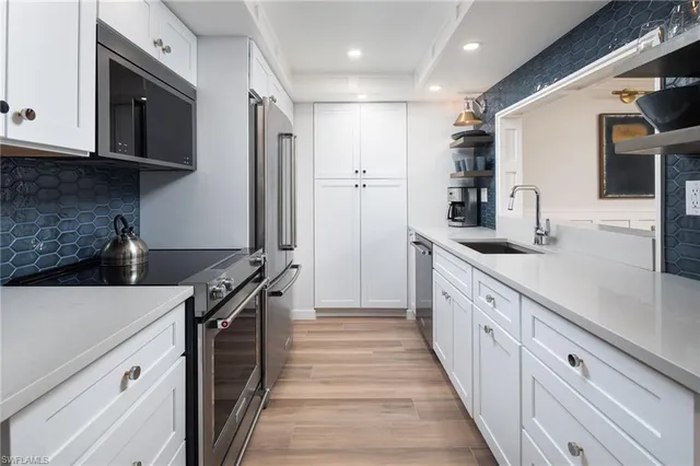 a kitchen with stainless steel appliances granite countertop a sink and a stove