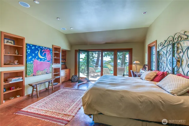 a bed sitting in a spacious bedroom next to a window