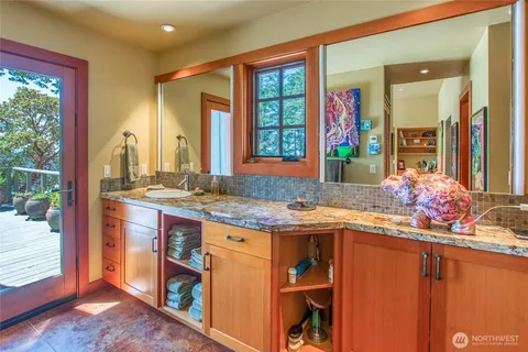 a bathroom with a granite countertop sink a mirror and shower