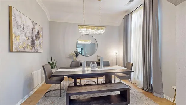 a view of a dining room with furniture a chandelier and wooden floor