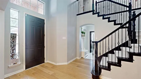 a view of staircase with lots of frames on wall and a window