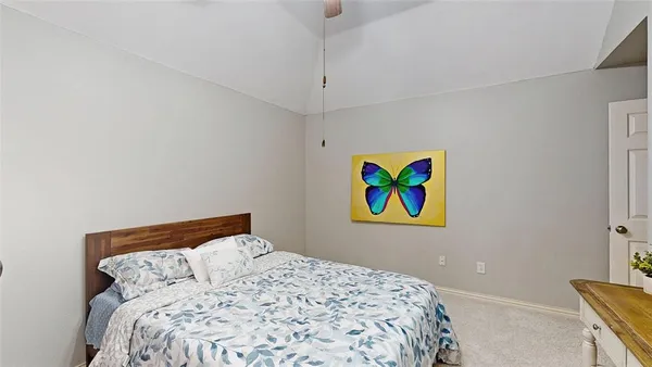 a bedroom with a bed and painting on the wall
