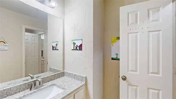 a bathroom with a granite countertop sink and a mirror