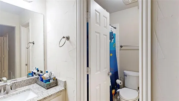 a bathroom with a granite countertop sink toilet and shower