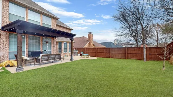 a view of a chair and table in backyard of the house