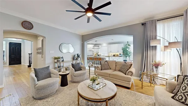 a living room with furniture a rug potted plant and a large window