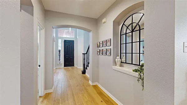 a view of a hallway with wooden floor and staircase