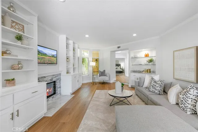 a kitchen with a sink stove a microwave a refrigerator and white cabinets with wooden floor