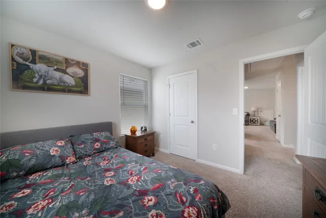 a bedroom with a bed and painting on the wall
