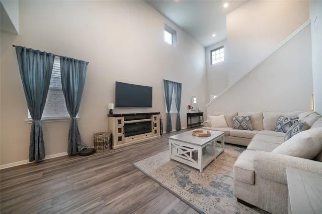 a living room with furniture a flat screen tv and kitchen view