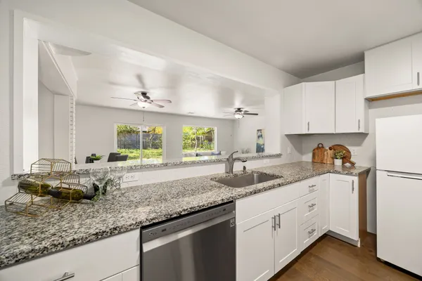 a kitchen with granite countertop a sink cabinets and window