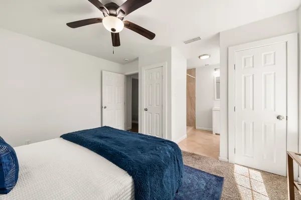 a spacious bedroom with a bed and a ceiling fan