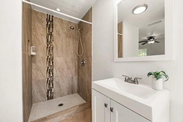 a bathroom with a shower sink and mirror