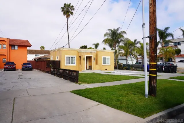 a front view of a house with a yard and trees