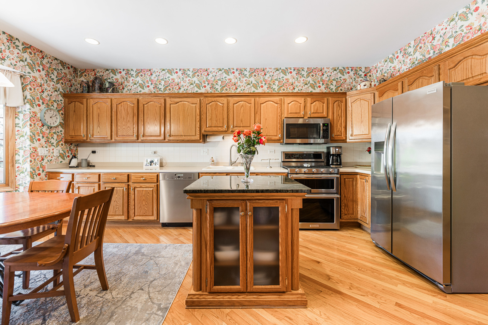 1607 Park Ridge Point Park Ridge, IL 60068 - Photo 7 of 41 a kitchen with stainless steel appliances granite countertop a stove top oven a refrigerator a sink and a dining table with wooden floor