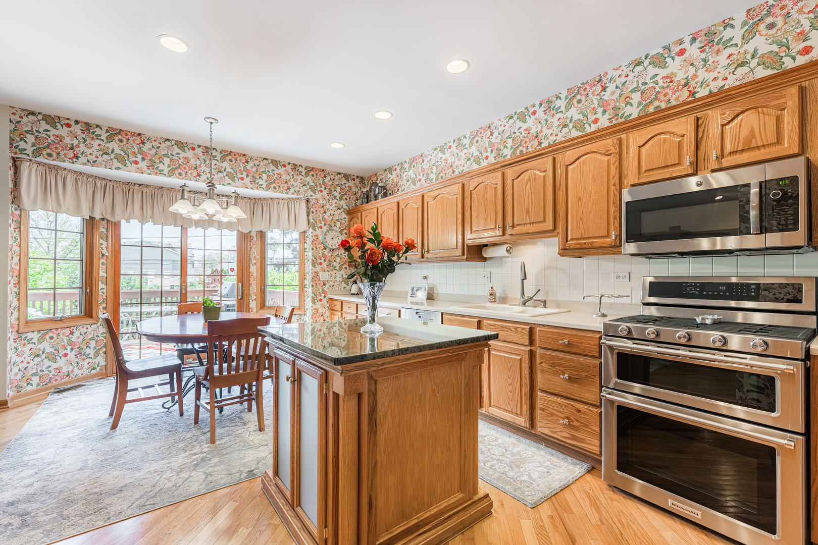 1607 Park Ridge Point Park Ridge, IL 60068 - Photo 10 of 41 a kitchen with stainless steel appliances granite countertop a stove top oven a sink dishwasher a dining table and chairs with wooden floor