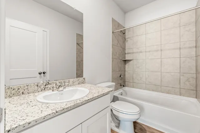 a bathroom with a sink toilet vanity and shower