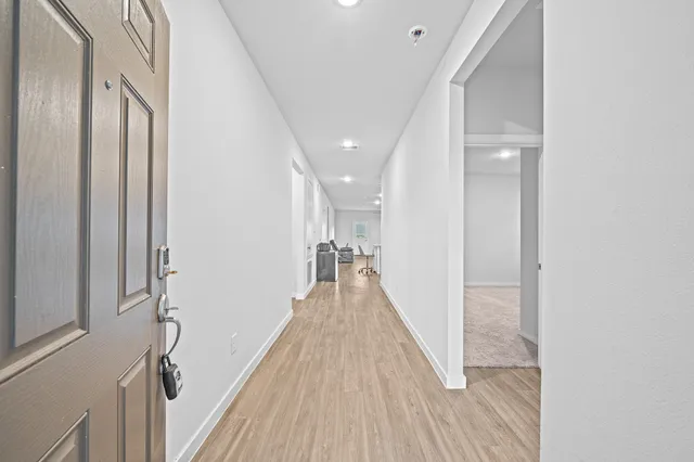 a view of a hallway with wooden floor and staircase