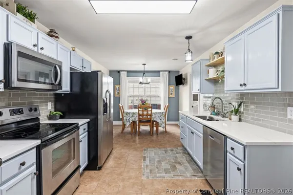 a kitchen with stainless steel appliances a stove refrigerator sink and microwave