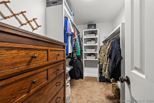 a view of walk in closet with clothes and shoes