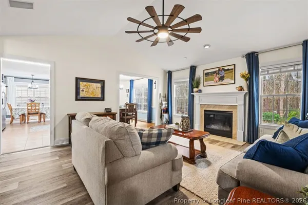 a living room with furniture a chandelier and a fireplace