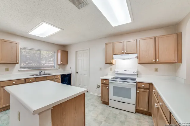 a kitchen with a stove a sink and a refrigerator