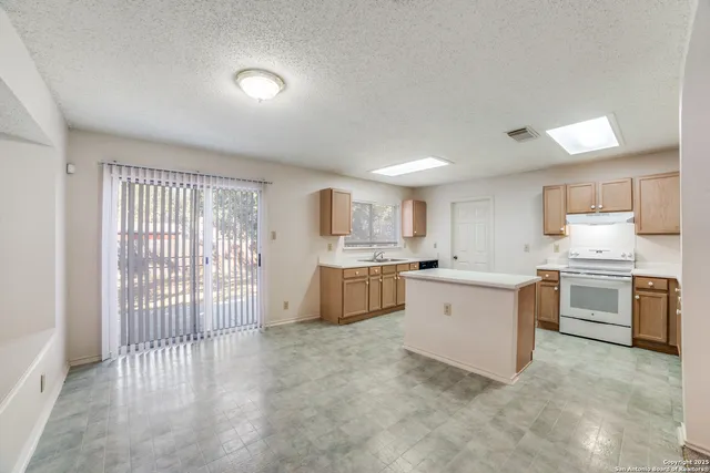 a kitchen with a white stove top oven and white cabinets