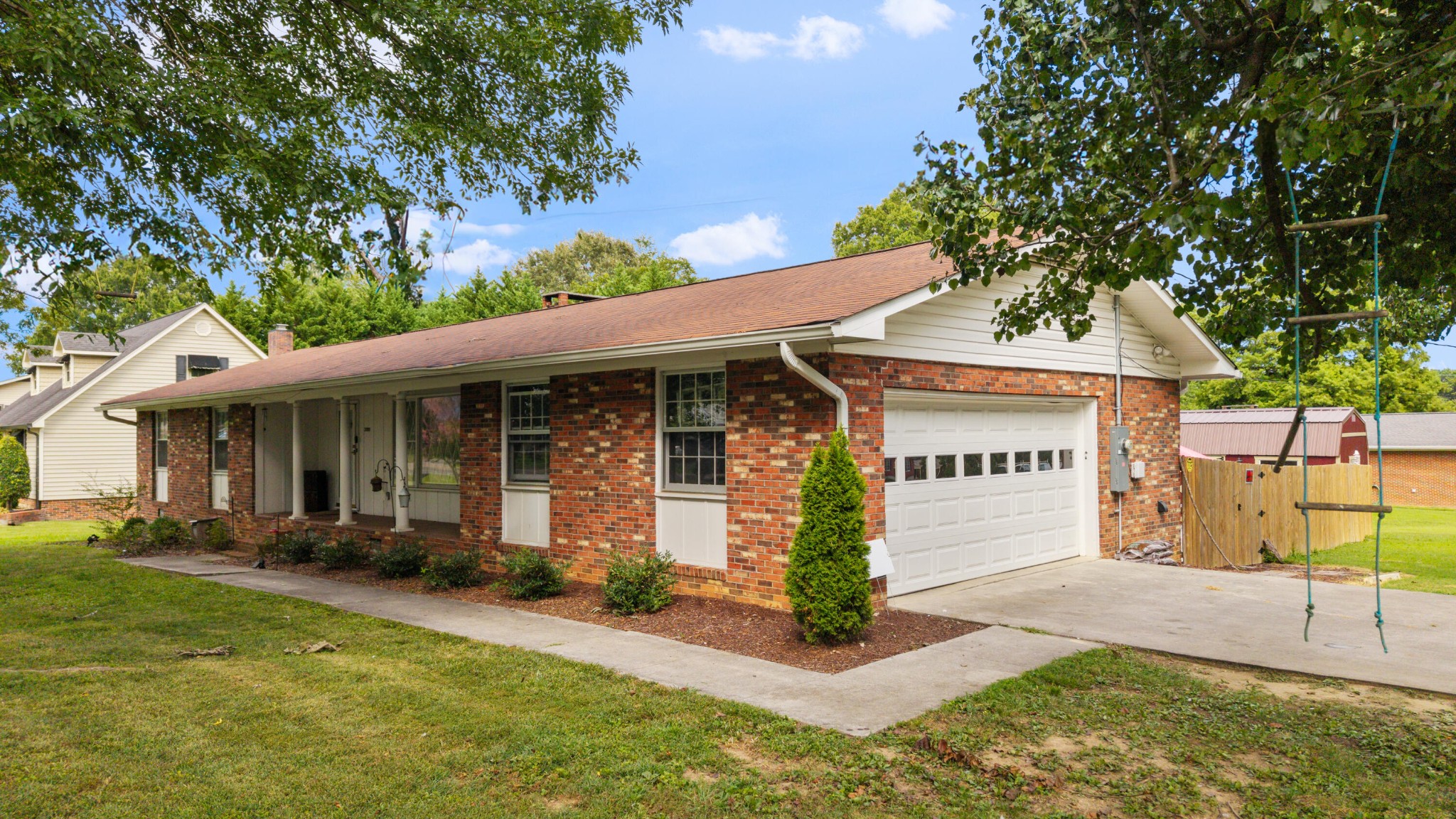 a front view of a house with a yard and potted plants