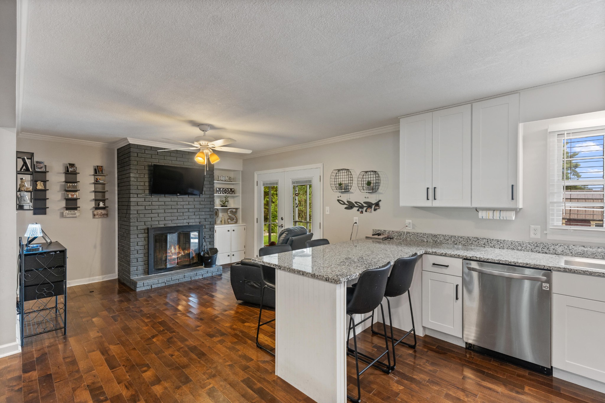 2000 Georgetown Road Northwest Cleveland, TN 37311 - Photo 7 of 36 a open kitchen with granite countertop a stove top oven a sink dishwasher and a fireplace with wooden floor