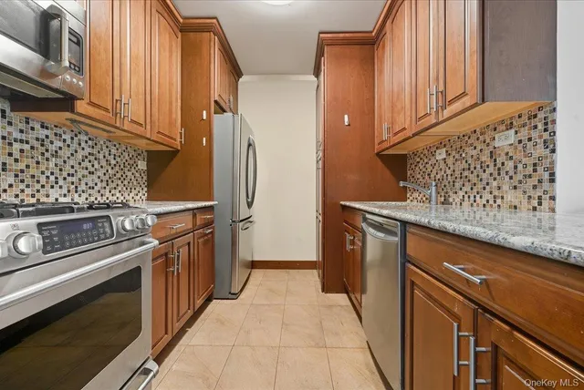a kitchen with stainless steel appliances granite countertop a refrigerator and a stove