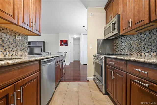 a kitchen with stainless steel appliances granite countertop a refrigerator and a stove